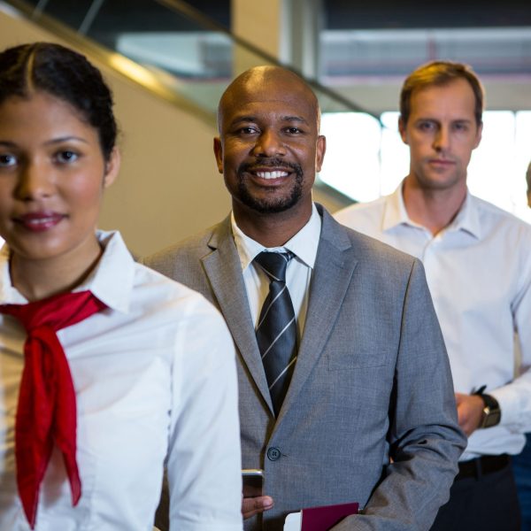 Portrait of female staff and passengers standing in the airport terminal